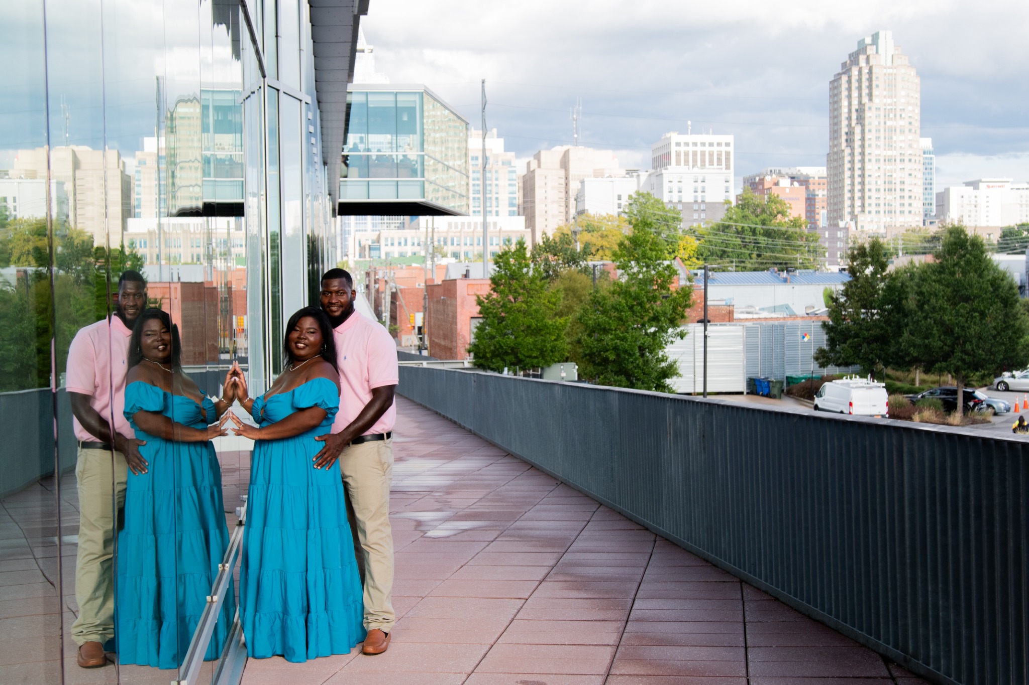 A wide rooftop portrait of Anita and Brian with the city skyline in the background